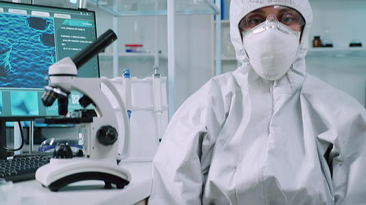 微生物学家穿着皮西服坐在实验室里看着相机视频的预览图