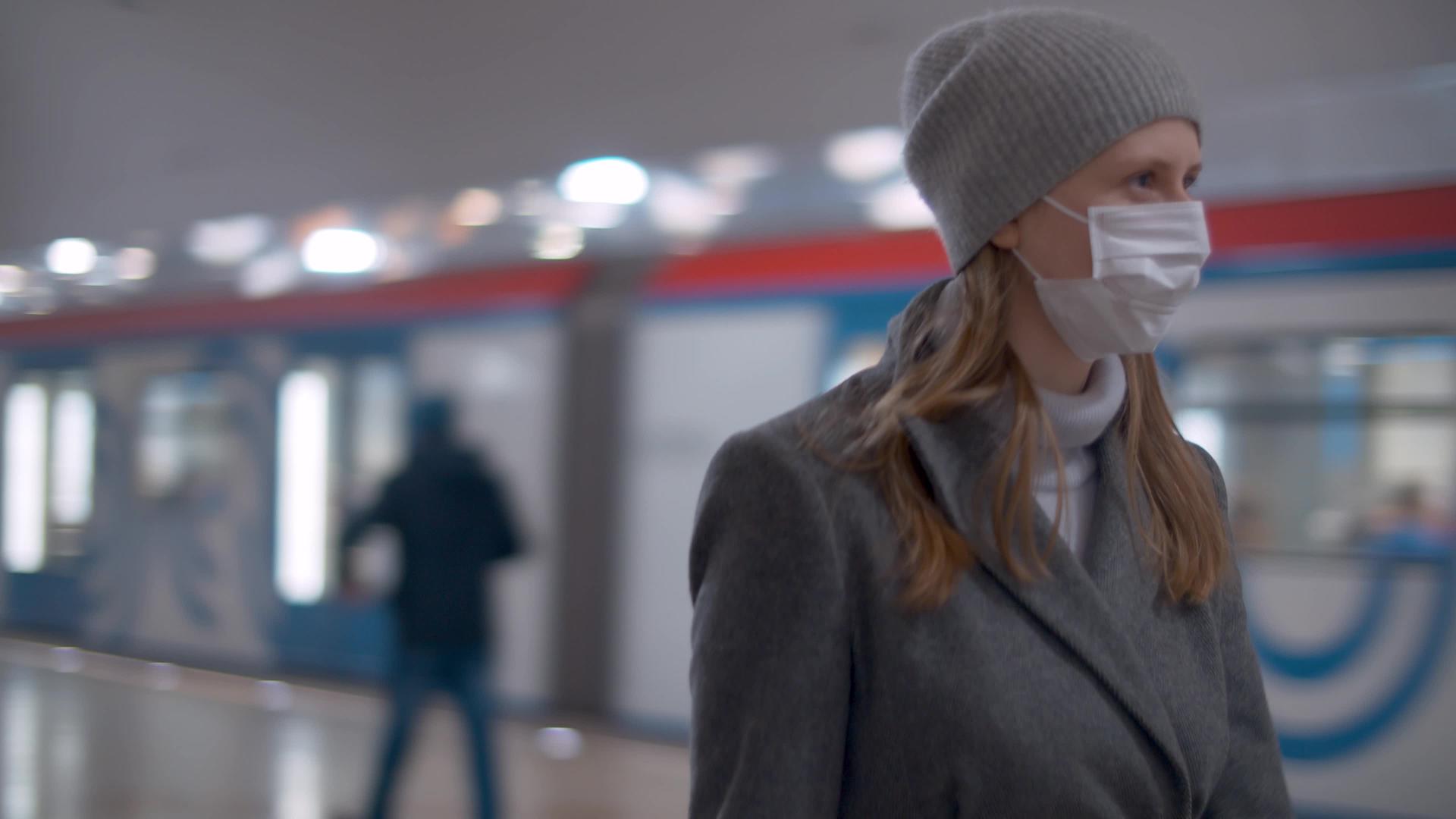 在地铁站行走时戴口罩的妇女视频的预览图