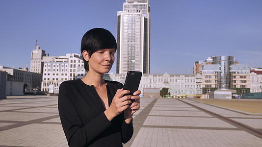 有吸引力的女性在露天使用手机视频的预览图