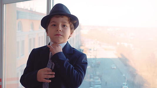 年轻男孩穿着商业西装、领带和帽子的肖像视频的预览图