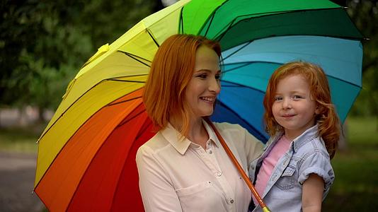 快乐的母亲和孩子在彩虹伞下视频的预览图