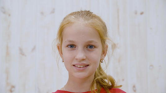 肖像中快乐微笑的女孩面对着光工作室背景中可爱的女孩视频的预览图