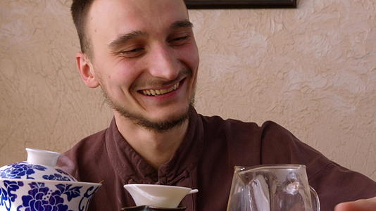 欢笑的茶大师享受新鲜饮料快乐的男人在东方餐厅喝酒视频的预览图
