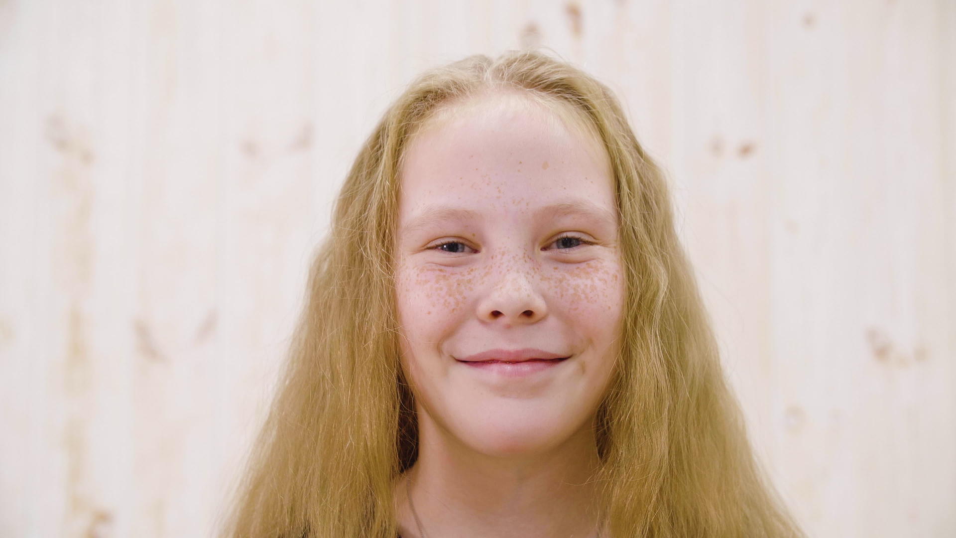 快乐红头发的女孩脸上有雀斑光工作室对着镜头微笑视频的预览图