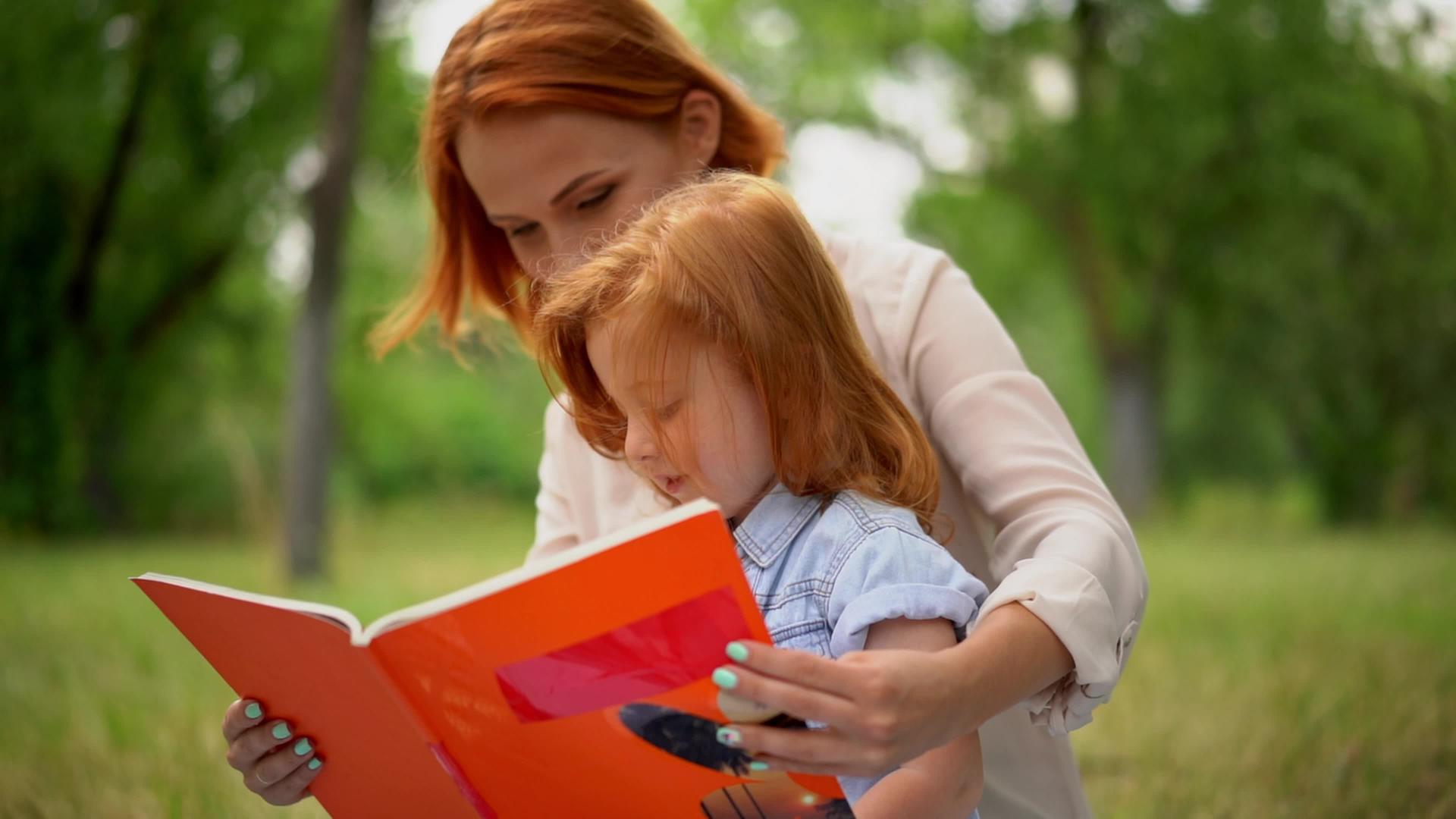 母亲和女儿在公园里看书视频的预览图