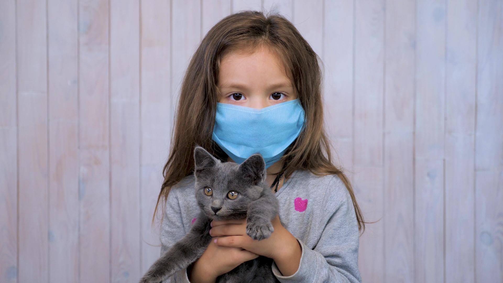 浅灰色黑发女孩在浅灰色的墙壁背景上戴着医用防护口罩视频的预览图
