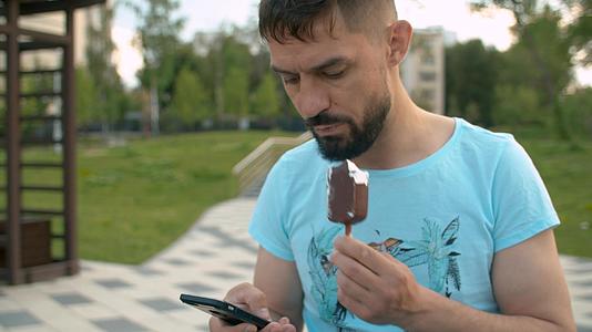 男手滚动智能手机人公园特写成人夏夜的生活方式视频的预览图