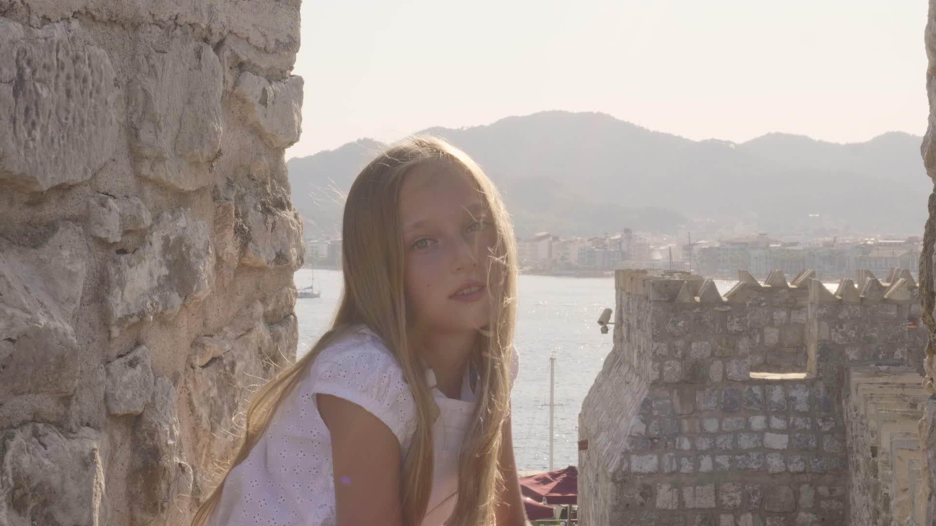 美丽的女孩在石头堡垒和海景上的头发旅行视频的预览图