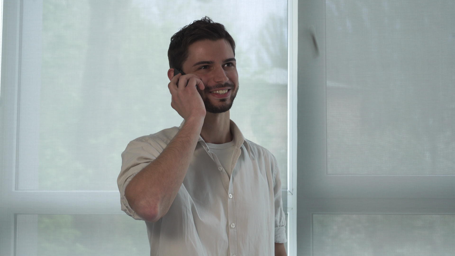 快乐男人在室内用智能电话聊天的肖像视频的预览图