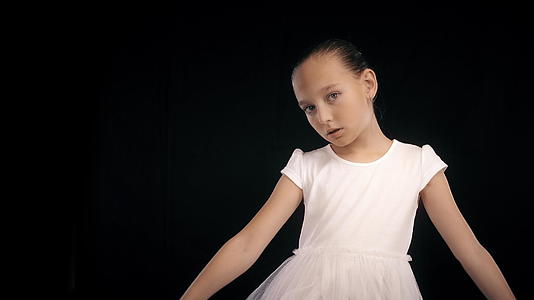 一个十几岁的女孩穿着白色的舞裙和黑色的背景视频的预览图