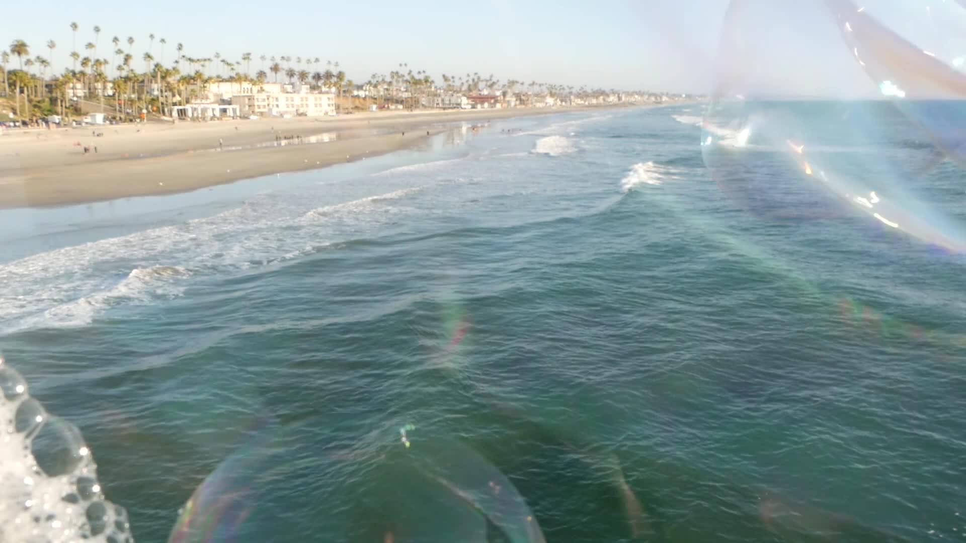 在加州的海洋码头吹肥皂泡夏天的背景模糊而有创意视频的预览图