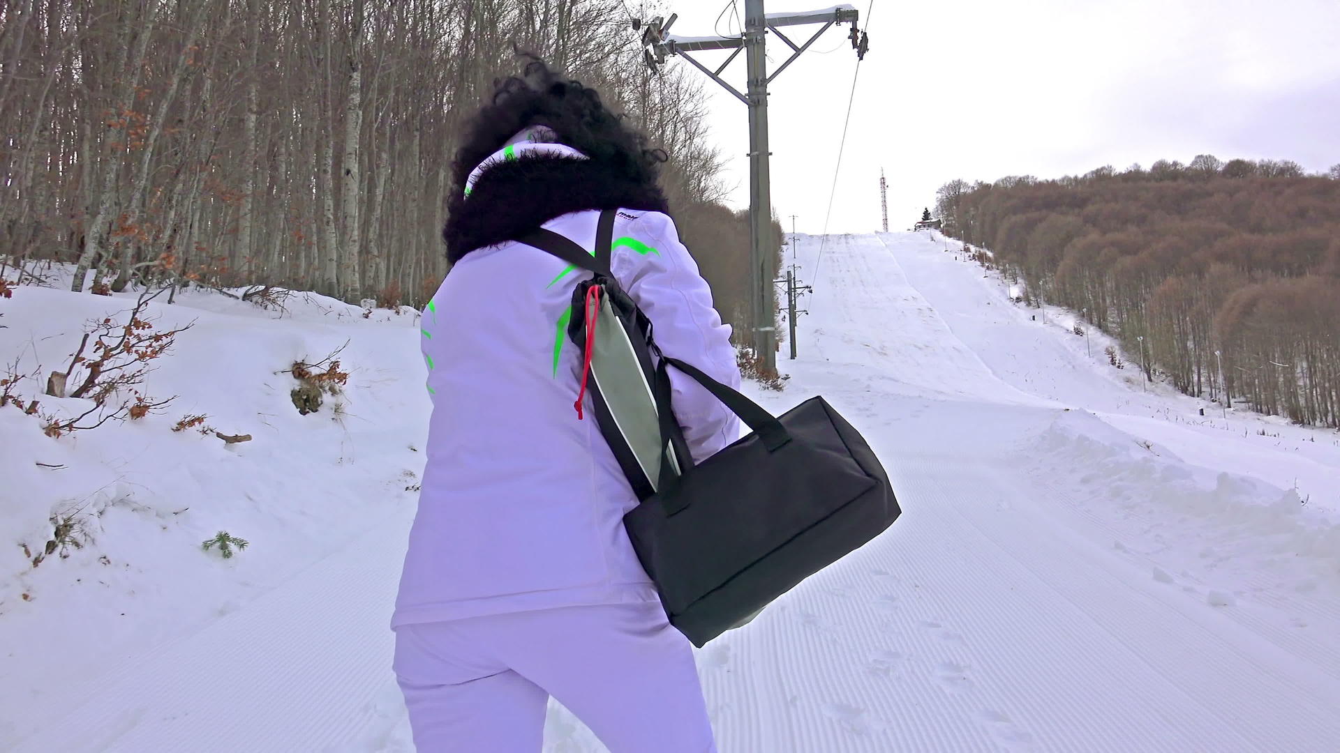 女人在陡峭的滑雪坡上行走视频的预览图