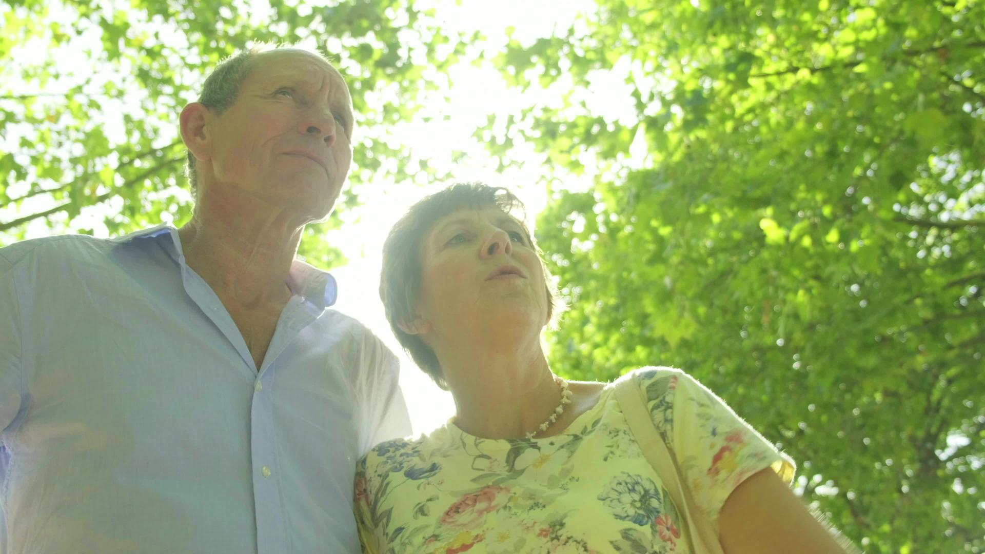 活跃的老年旅游夫妇在太阳的背斜线下视频的预览图