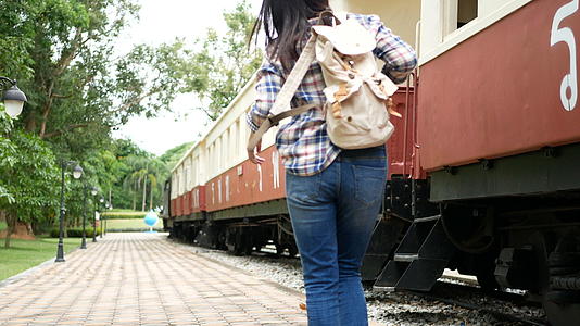4K火车站的亚洲旅游妇女背着背包上火车视频的预览图