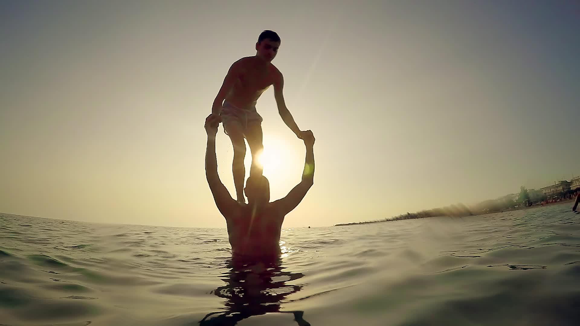 日落时在日落时从父亲的肩膀上在海里慢慢地转身视频的预览图