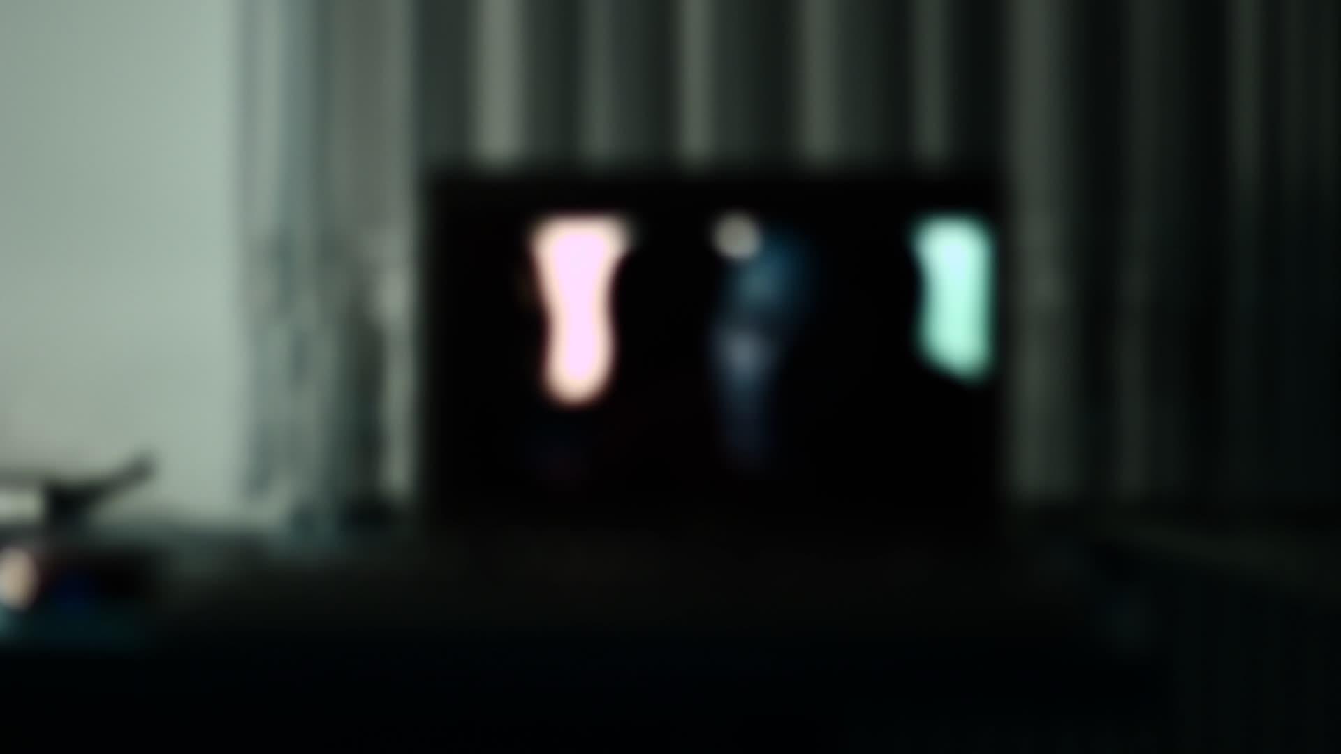 黑暗的房间和膝盖电脑播放电影视频的预览图
