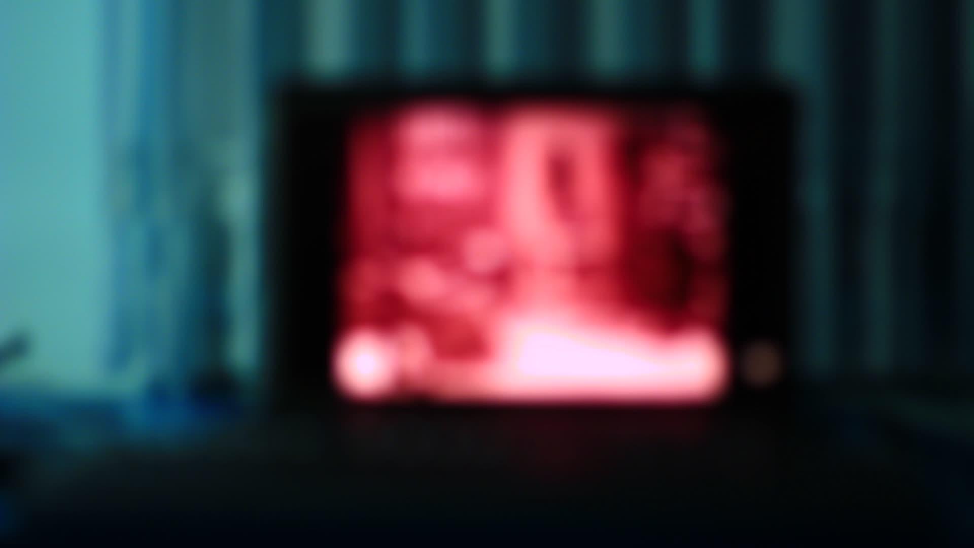 黑暗中的红色笔记本电脑屏幕视频的预览图