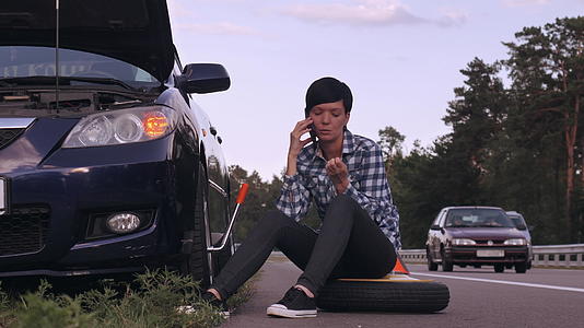 驾驶员使用智能手机更换户外轮胎视频的预览图