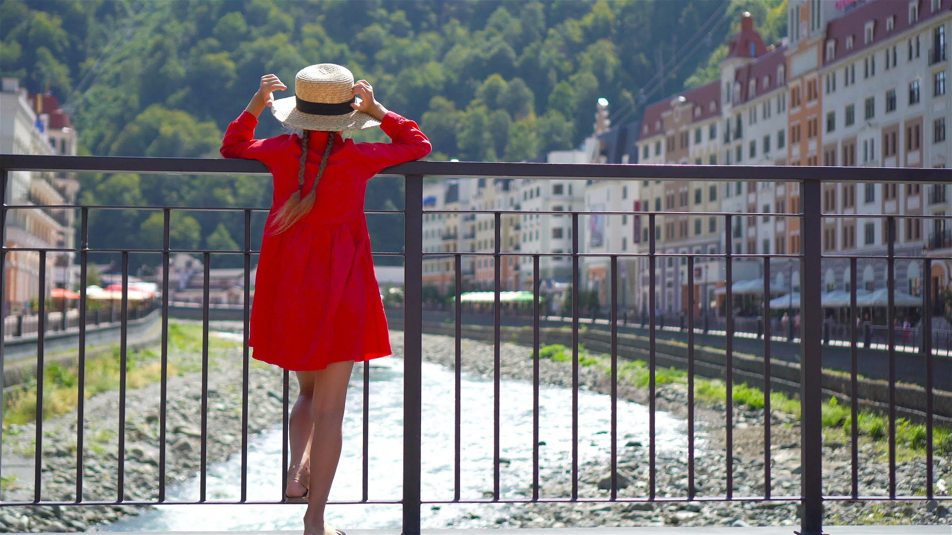 小女孩在欧洲城市的山河堤岸边戴着帽子视频的预览图