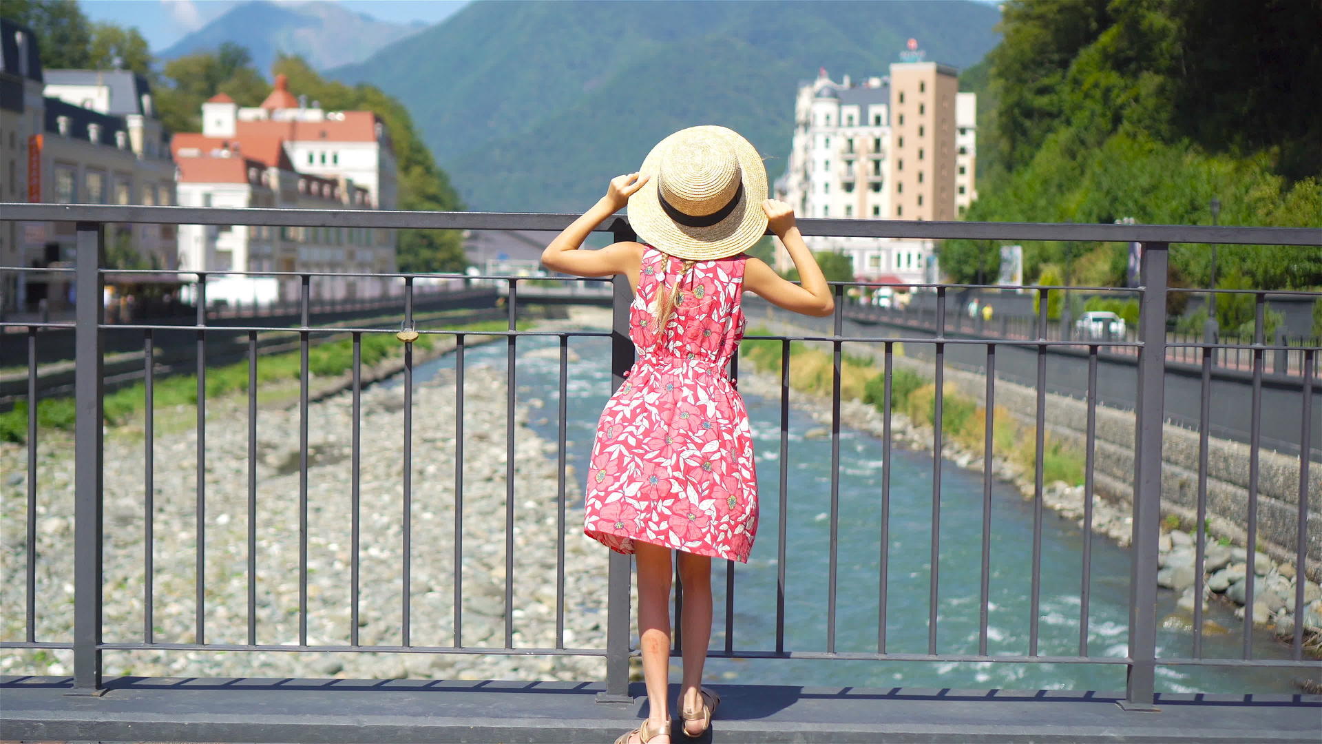 小女孩在欧洲城市的山河堤岸边戴着帽子视频的预览图