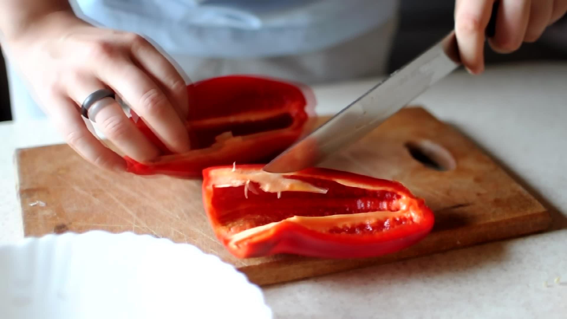 一位女士用一把锋利的在木砧板上切红辣椒用天然产品用天然产品视频的预览图