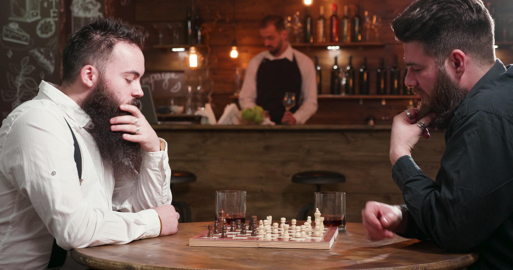 有胡子的男性朋友在酒吧见面下棋视频的预览图