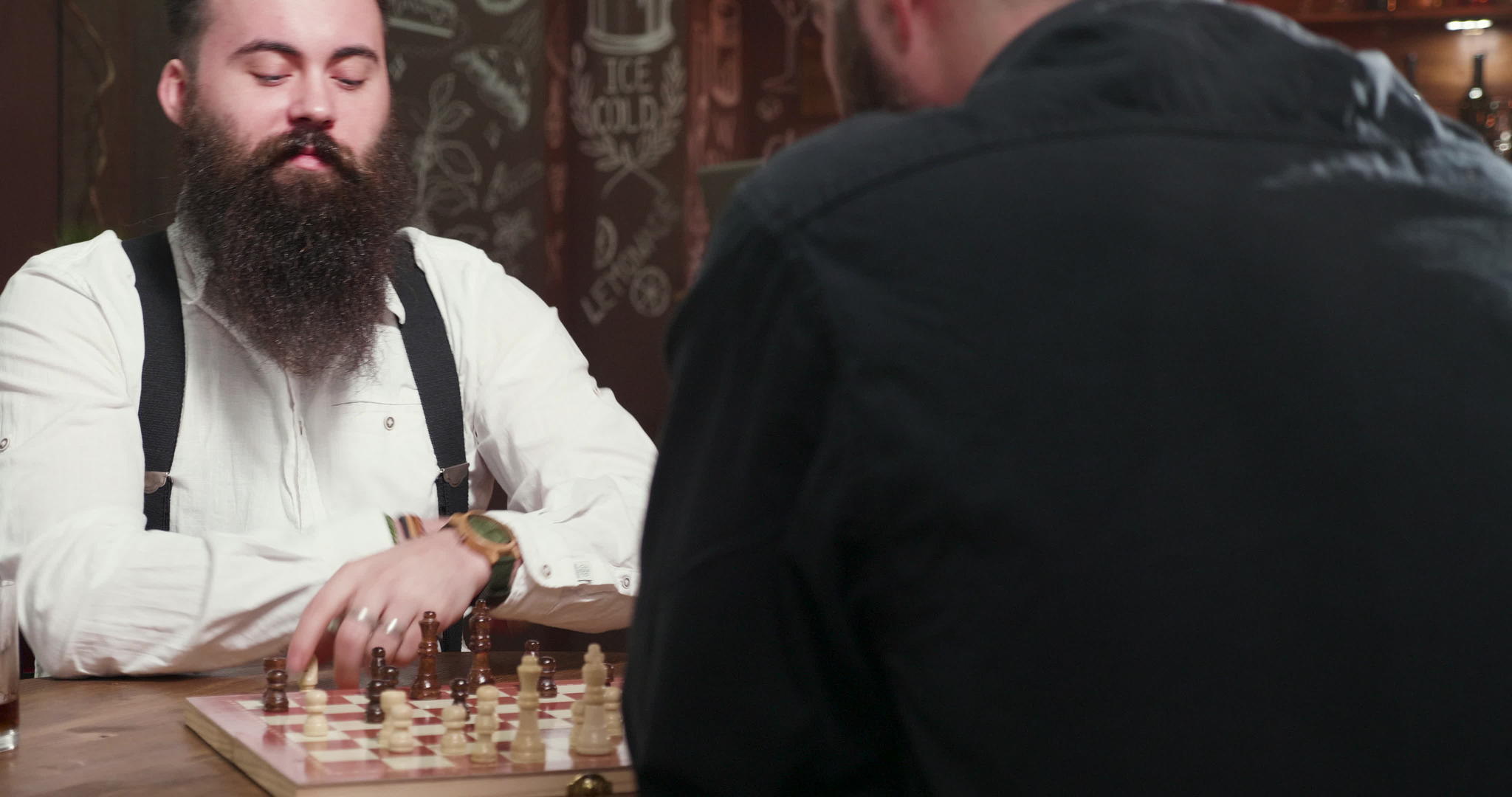 英俊的长胡子男人和朋友在酒吧下棋视频的预览图