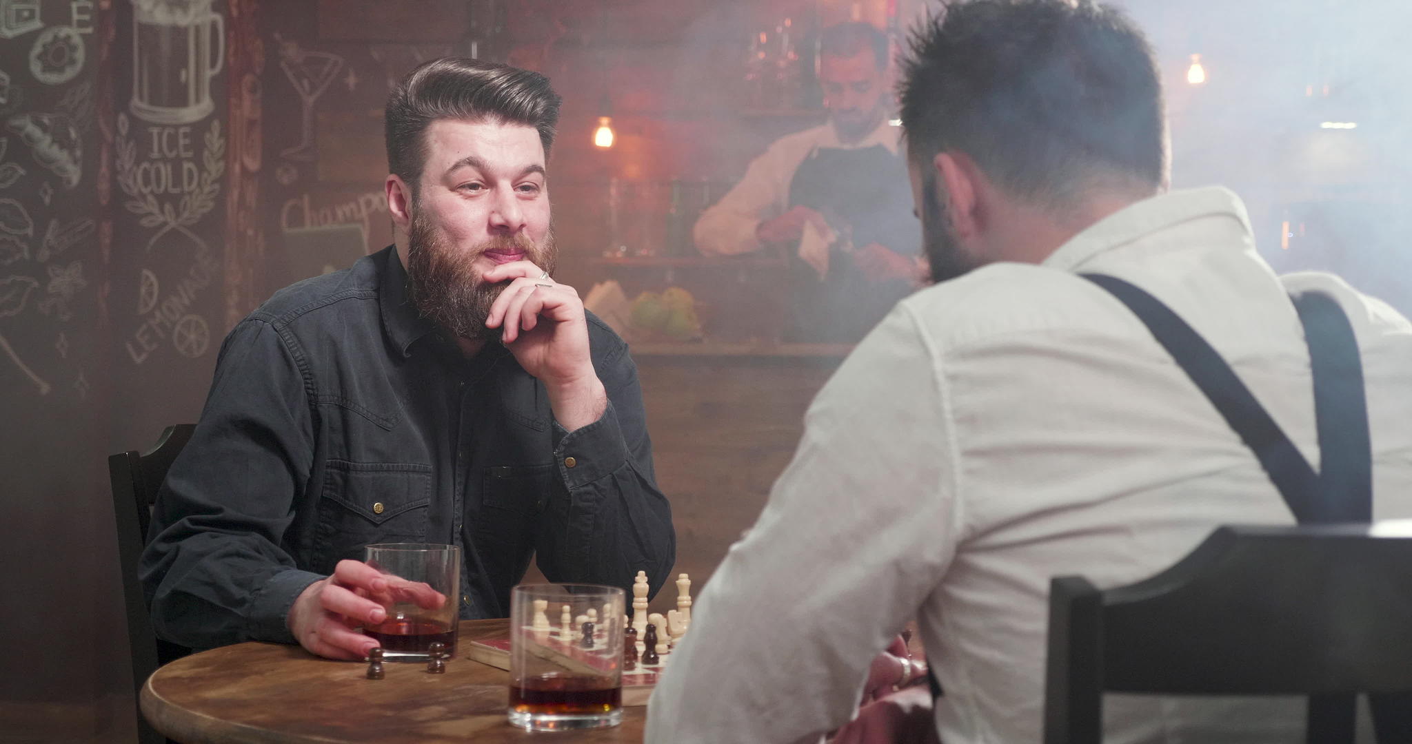 两个年轻的嬉皮士在酒吧的棋局比赛中喝了一杯威士忌酒视频的预览图