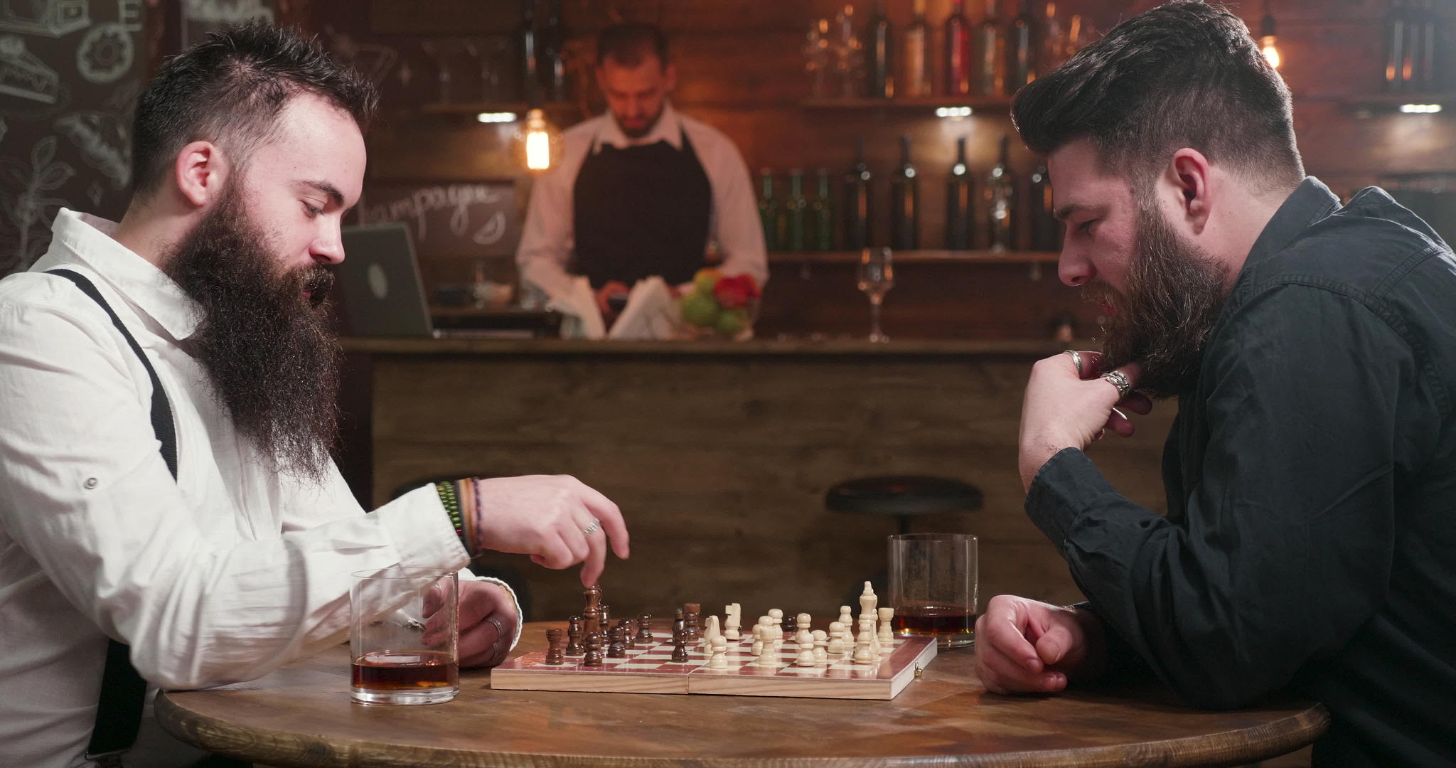 两个胡子时髦的朋友在酒吧玩象棋游戏视频的预览图