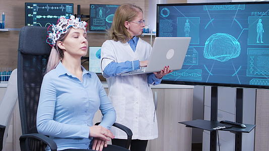 神经科学女医生检查了她笔记本电脑上的大脑数据视频的预览图