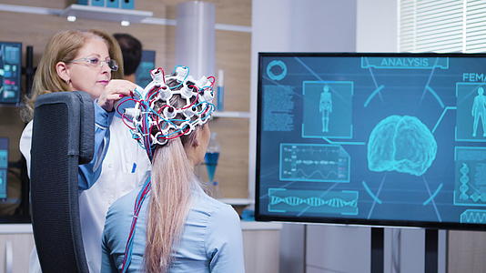 女性患者在电视屏幕上观察她的大脑活动视频的预览图