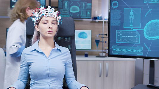 女性坐在椅子上戴着脑电波扫描仪耳机视频的预览图