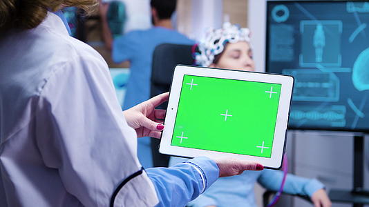 女医生在现代神经科学设施中检查平板电脑绿屏视频的预览图
