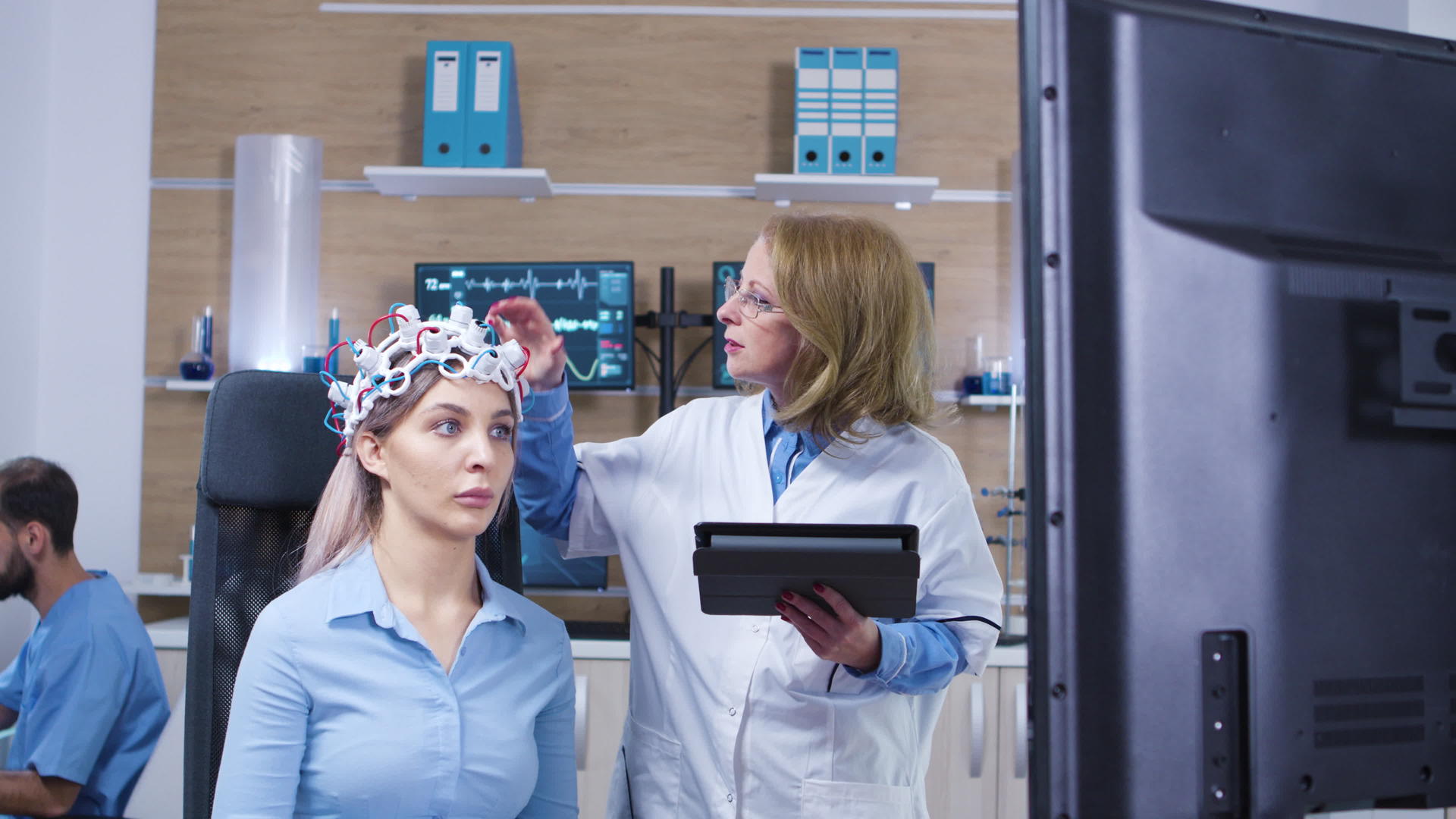 女医生检查其女性患者的脑活动视频的预览图