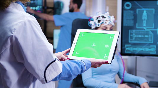 女医生在现代神经学实验室科学中持有绿色屏幕片视频的预览图