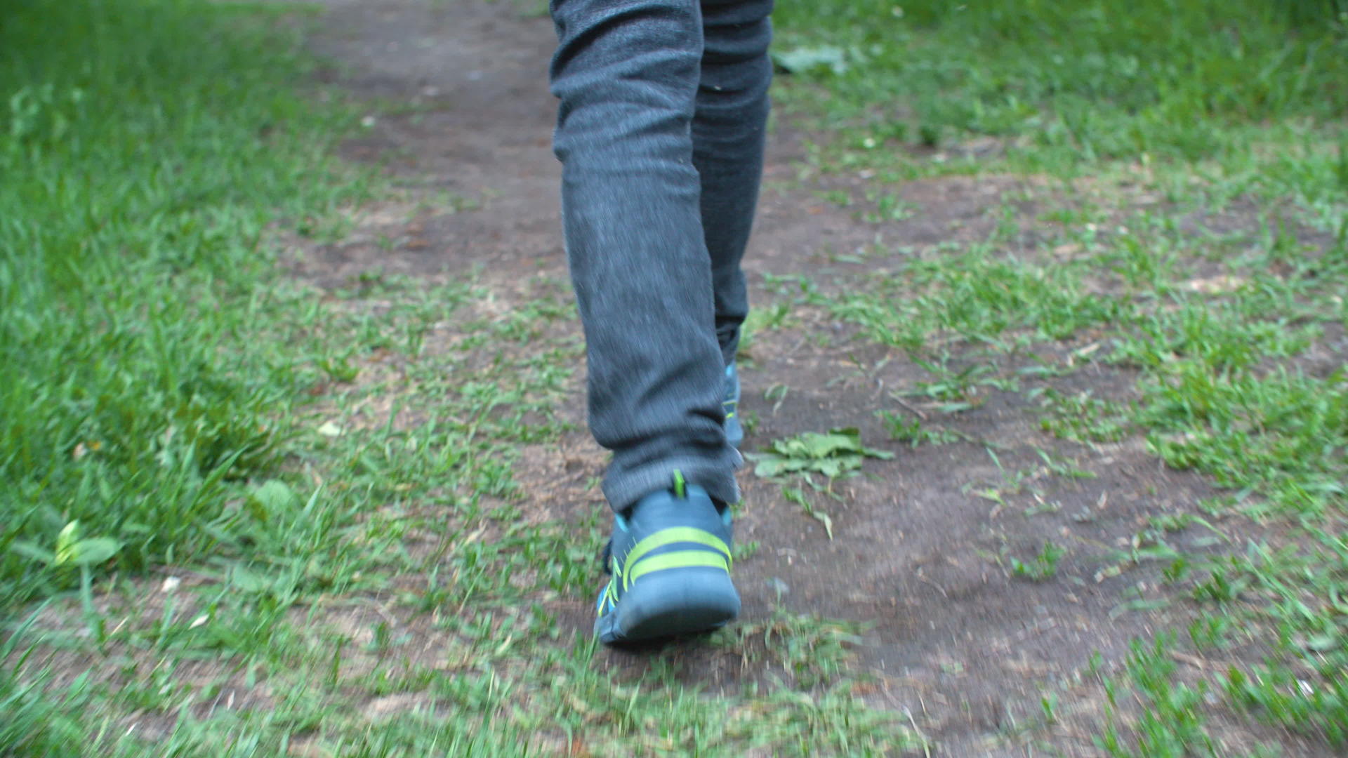 低层男孩穿着牛仔裤和运动鞋走在路上视频的预览图