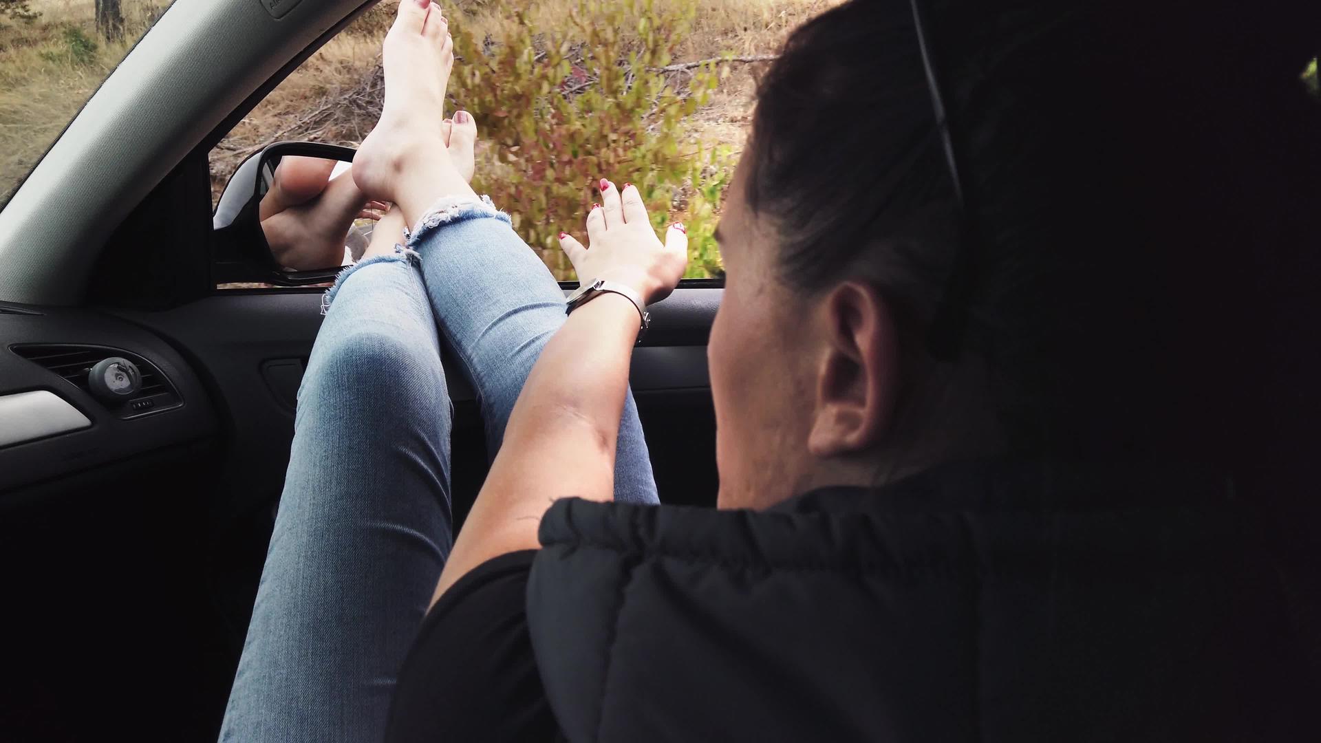 一个女孩在开着窗户的车里伸出双腿年轻女性喜欢开车旅行视频的预览图