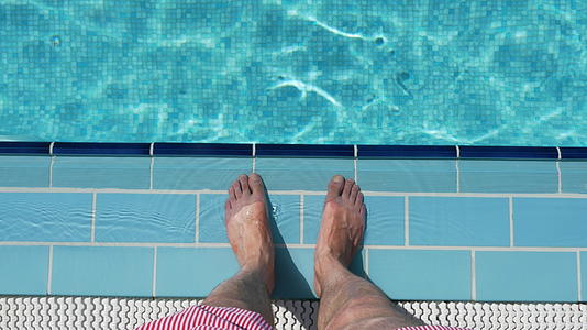 男人脚踩游泳池瓷砖视频的预览图