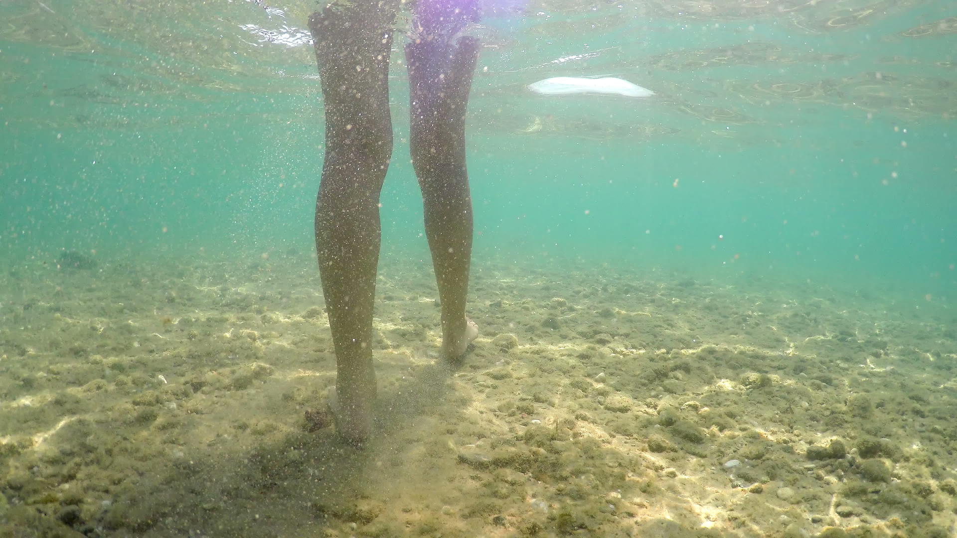用石头在粗糙的海床上行走的女性脚在水下倾斜视频的预览图