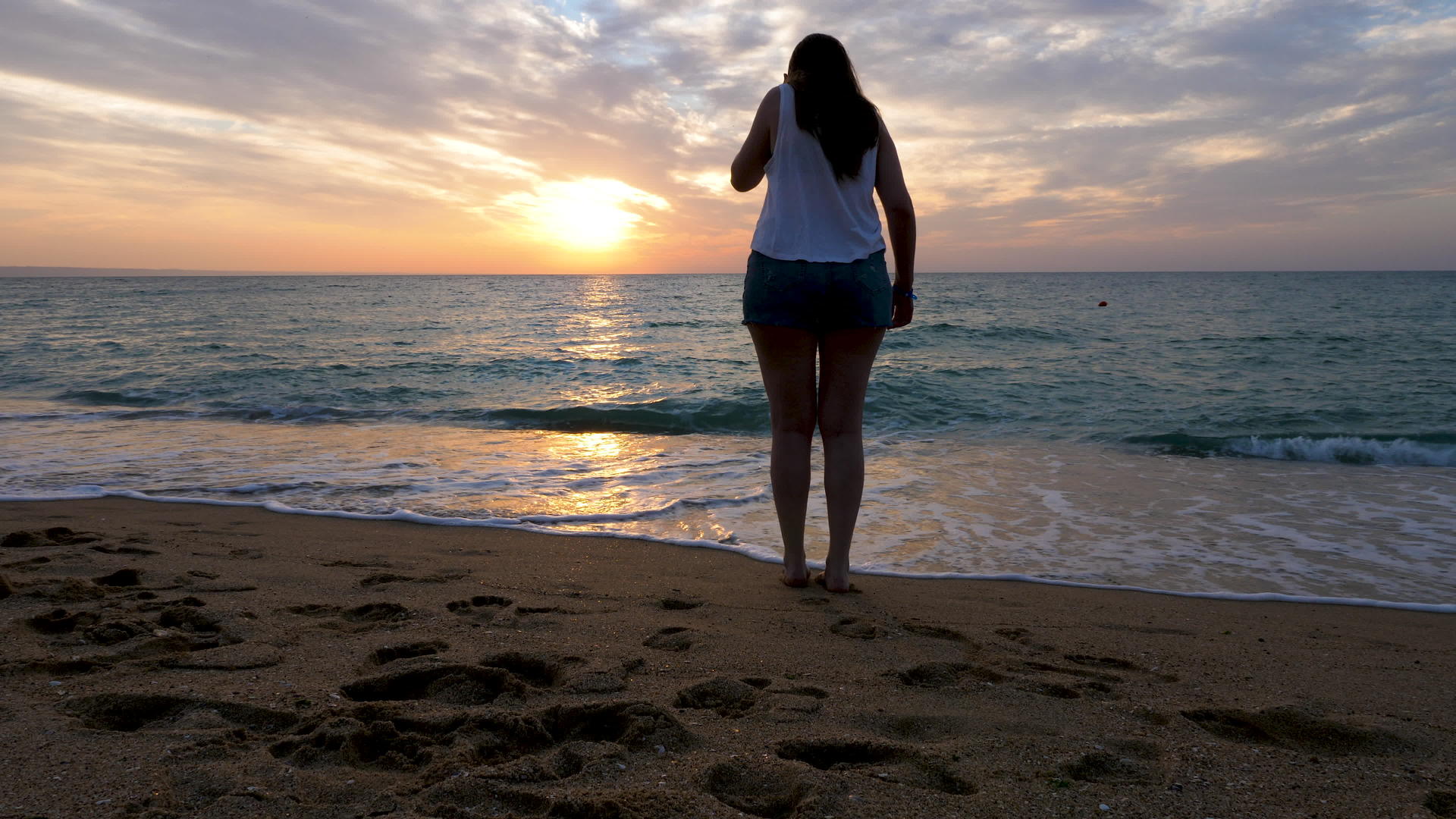 日出时在海滩上的女人视频的预览图