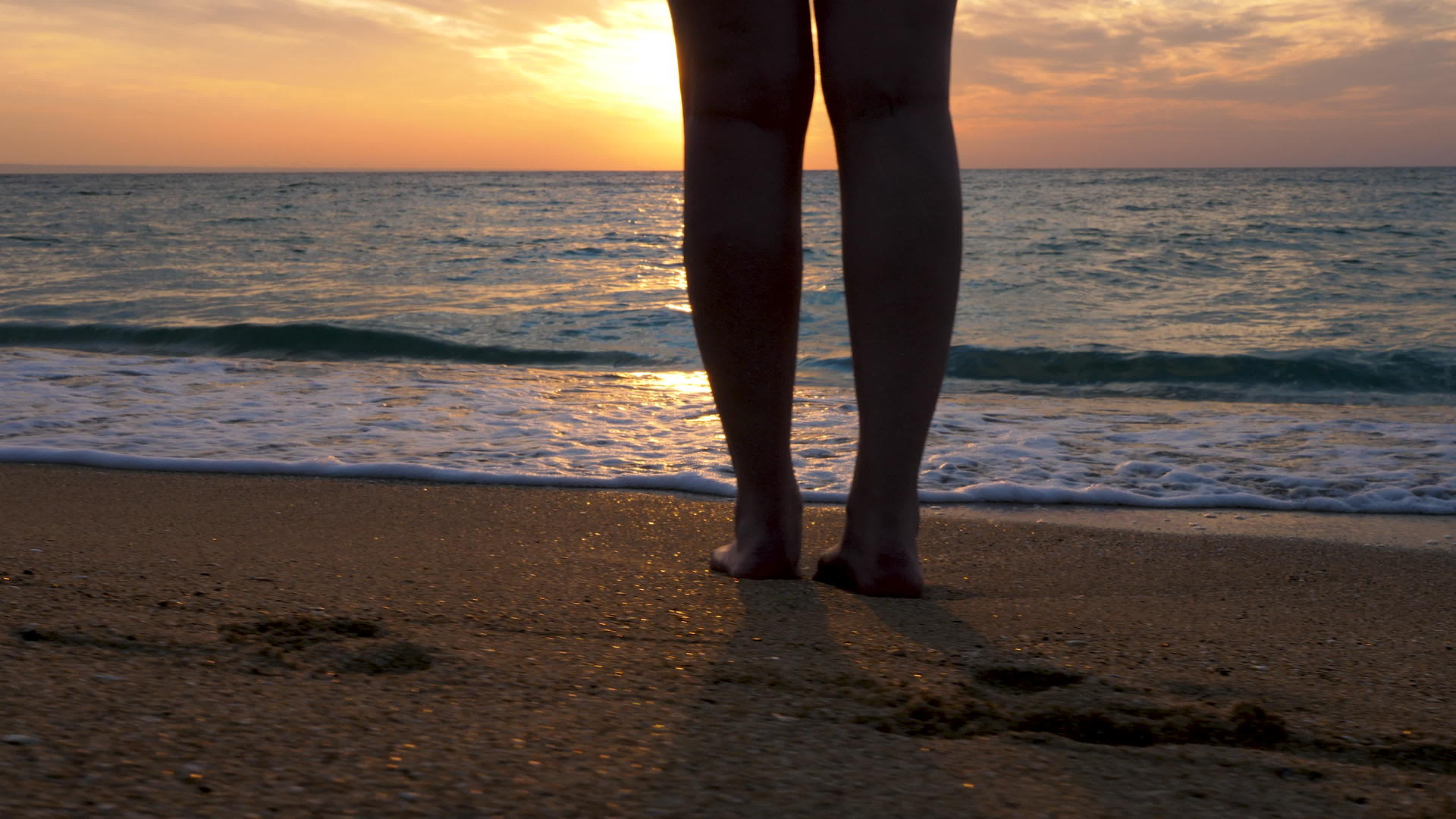 女人踩在海滩上在水中放松视频的预览图