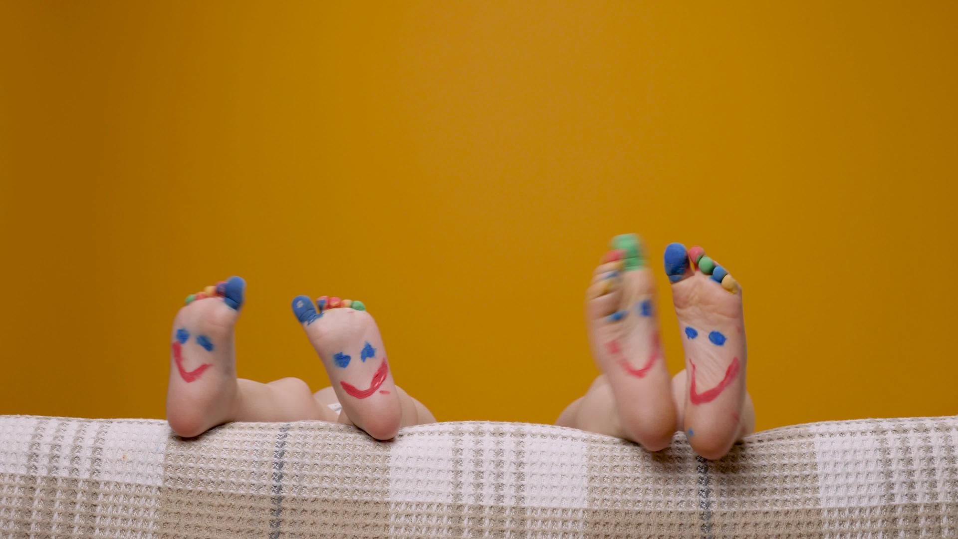 用笑脸画脚趾画有趣的脚孩子们赤脚玩耍和跳舞他们的脚趾五颜六色视频的预览图