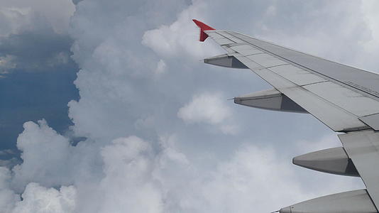 4K飞机通过飞机窗口的鸟瞰图飞进白云机翼视频的预览图