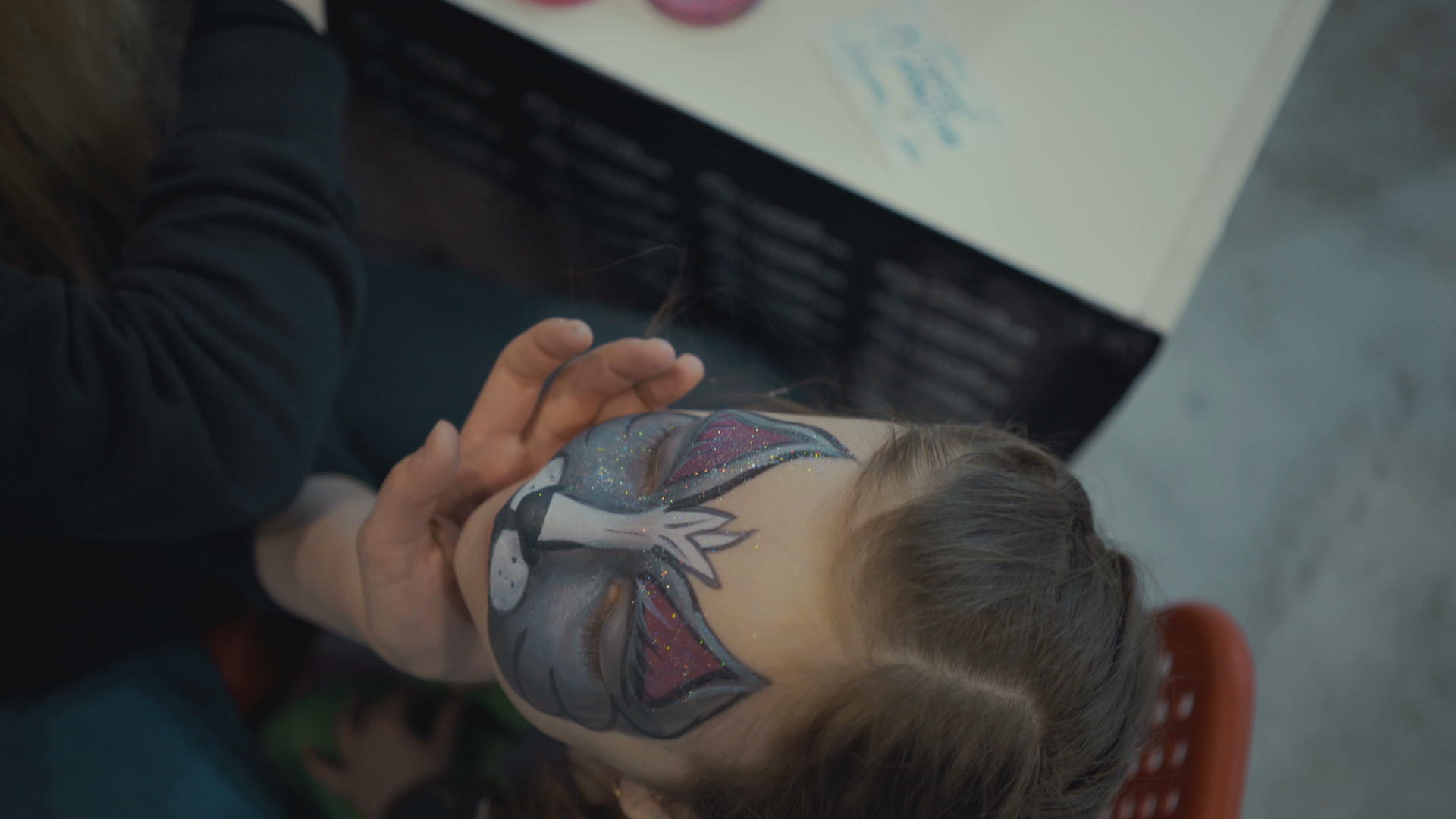 女人画脸给小女孩画水化妆品视频的预览图
