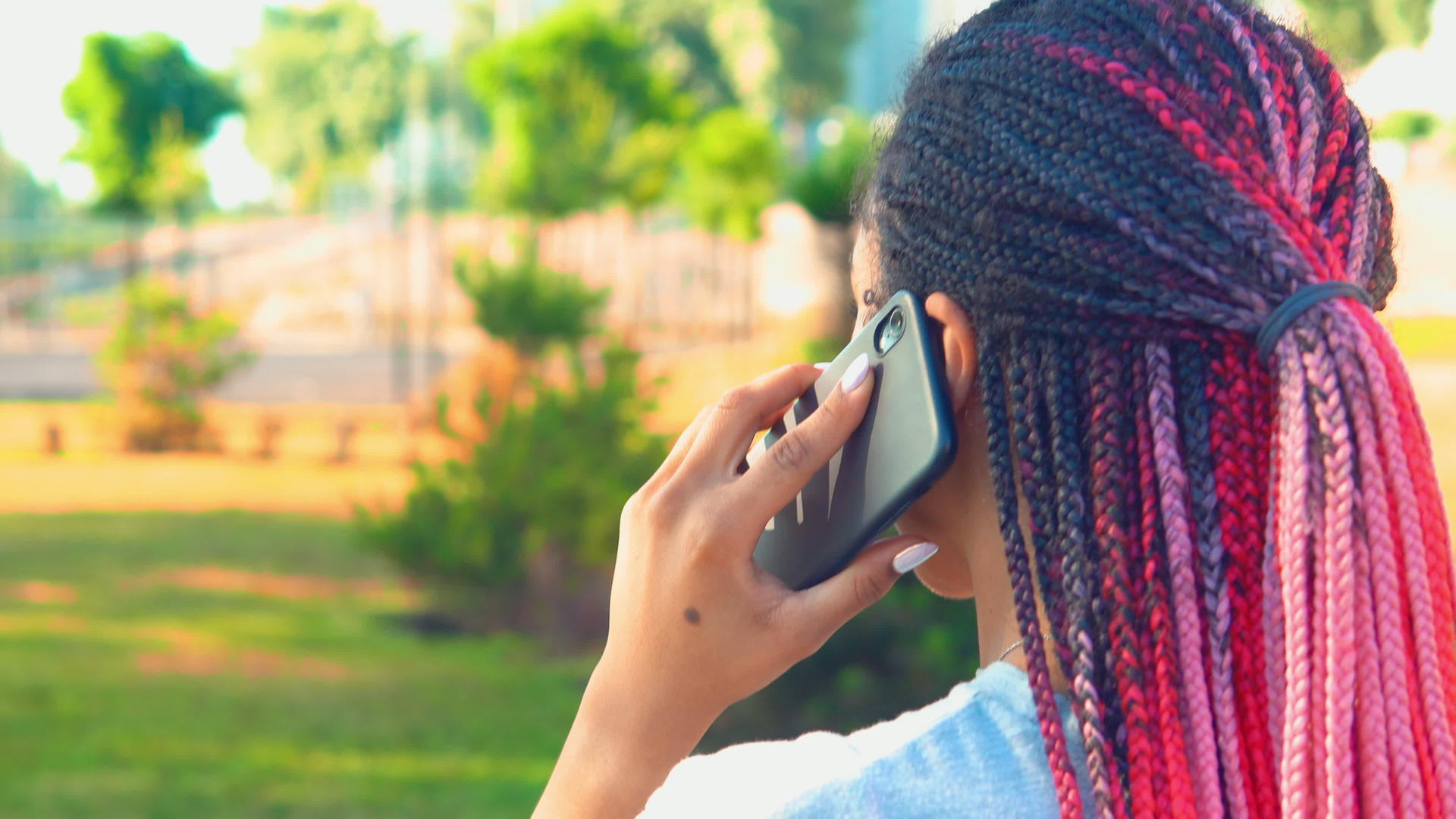 通过电话在外面聊天的非裔美国妇女在近距离观察后观看视频的预览图