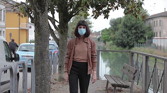 女孩在公园里散步时戴着医用面具在2号共同区视频的预览图