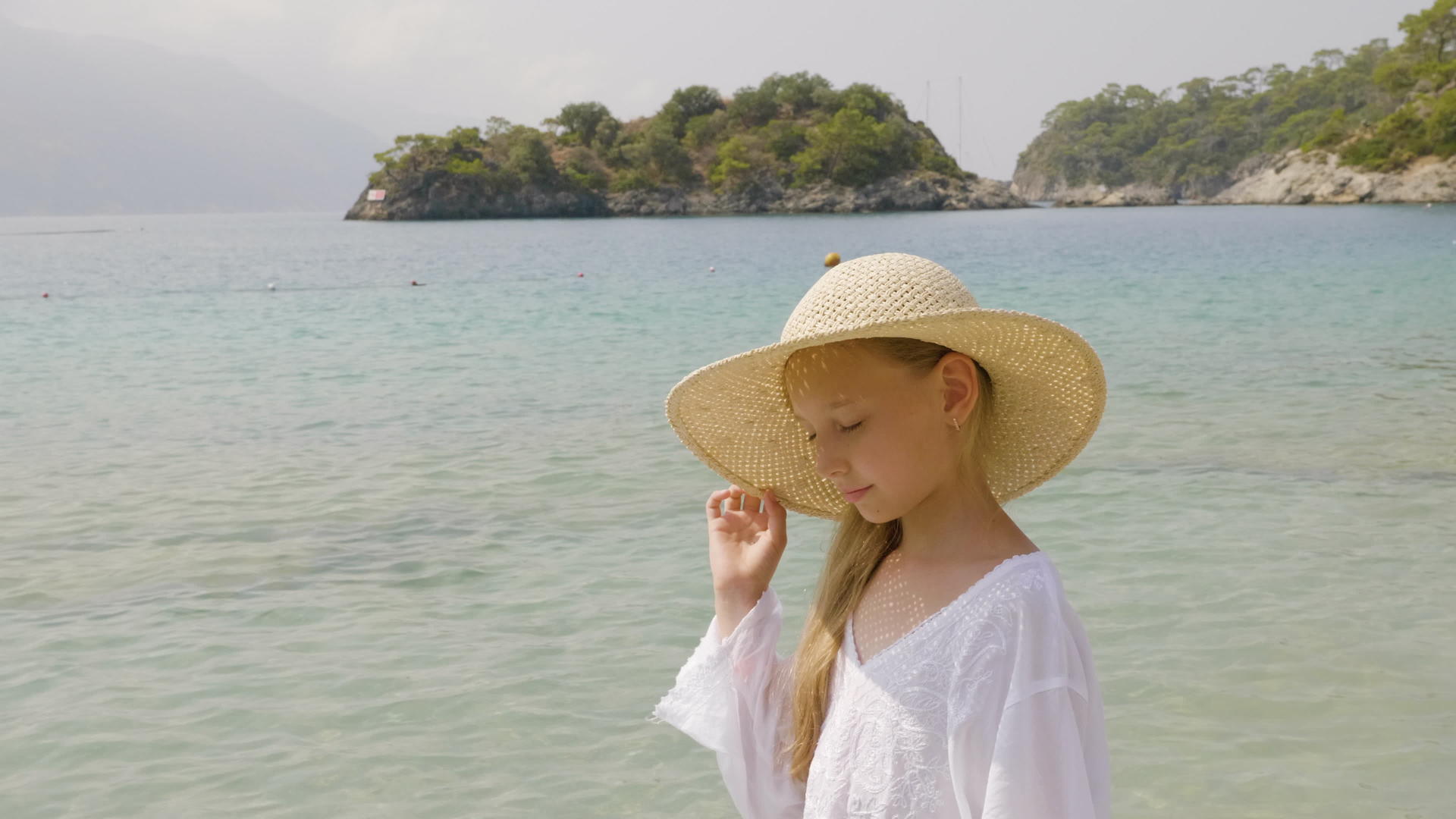 可爱的女孩在天堂海滩上的草帽夏天阳光明媚的海滩视频的预览图