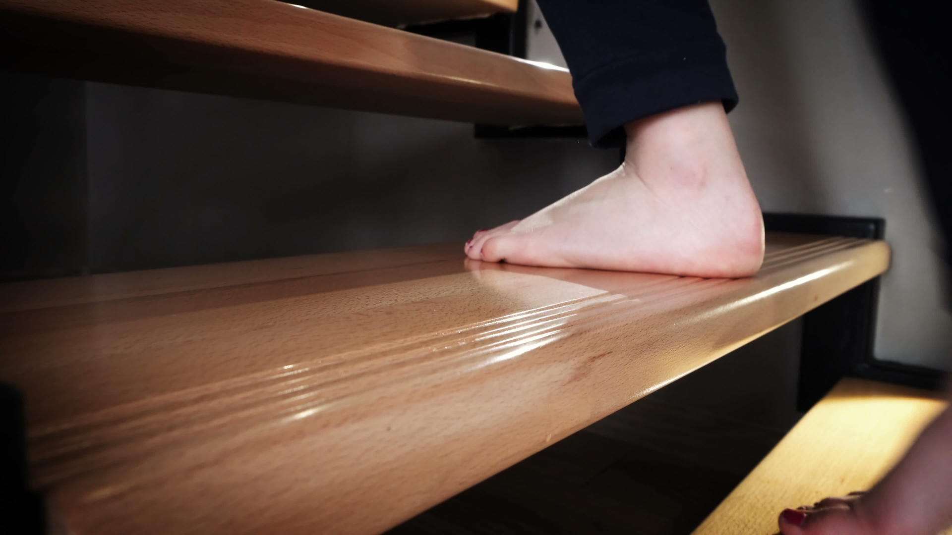 一个十几岁的女孩的腿在家里走在豪华的木楼梯上视频的预览图