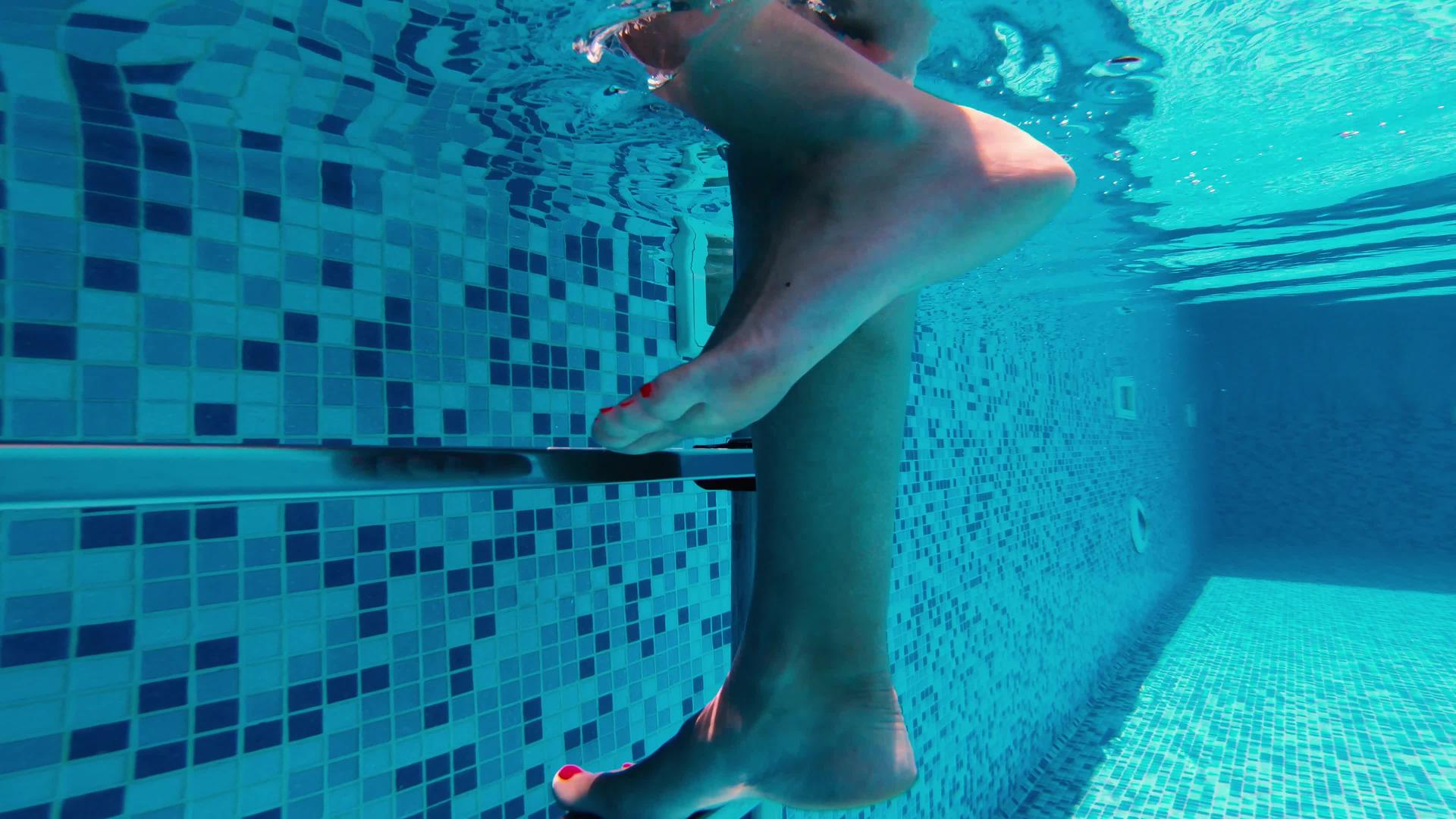 水下射出的女子腿爬上游泳池的金属梯子视频的预览图