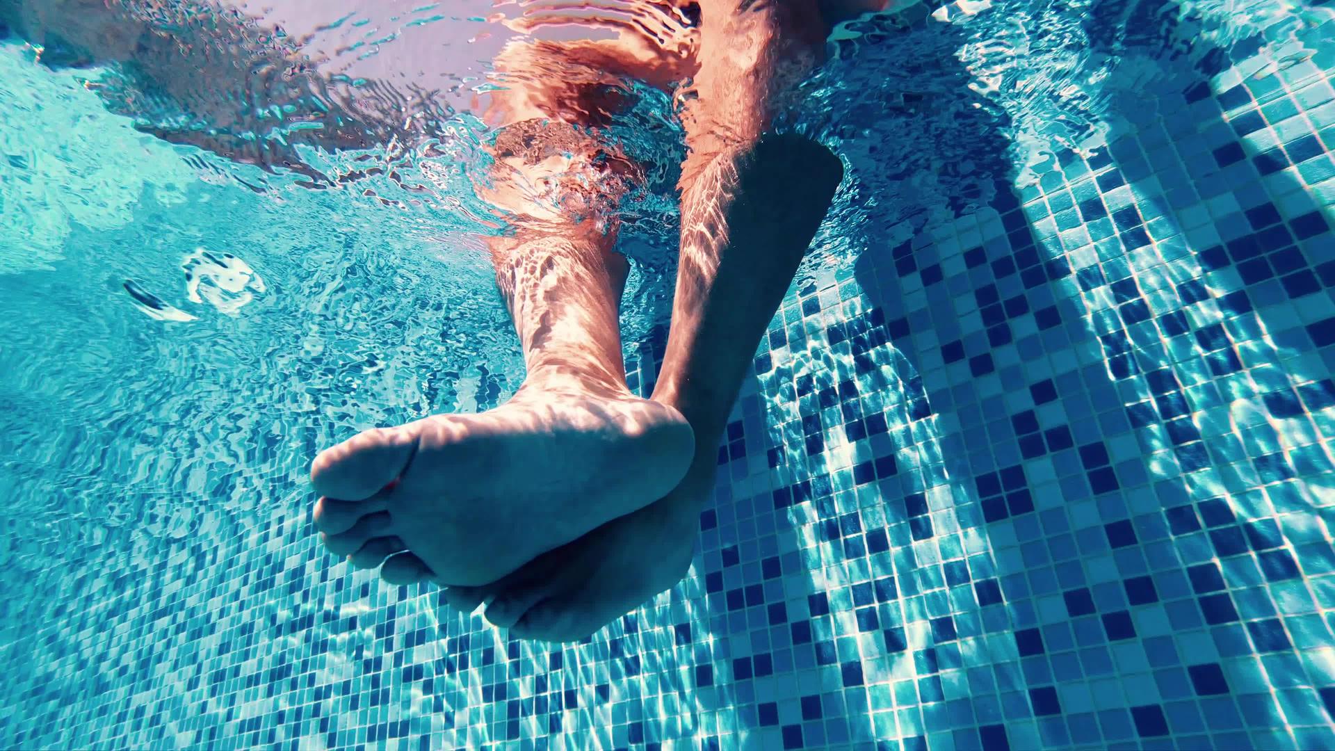 成人腿在水下游泳池中摇摆视频的预览图